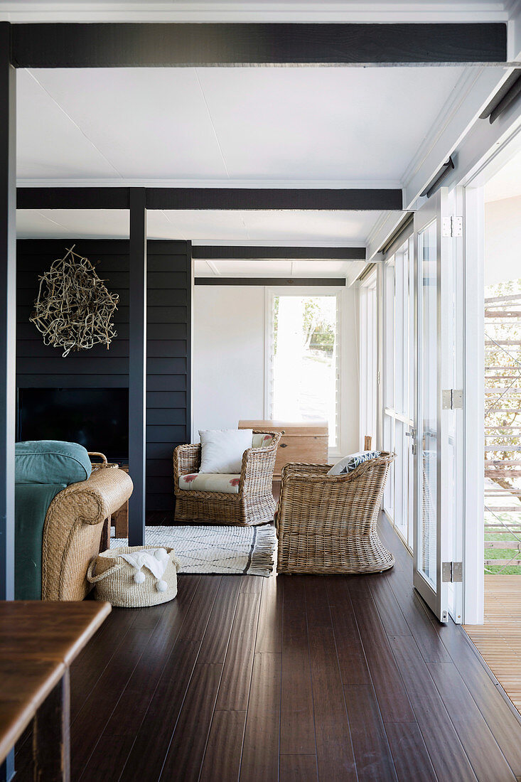 Open living room, rattan armchair in front of terrace door