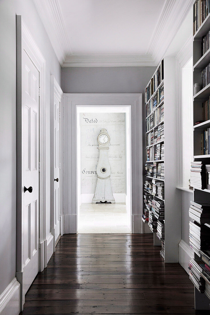 Classic hallway with bookshelves and cassette doors to the grandfather clock