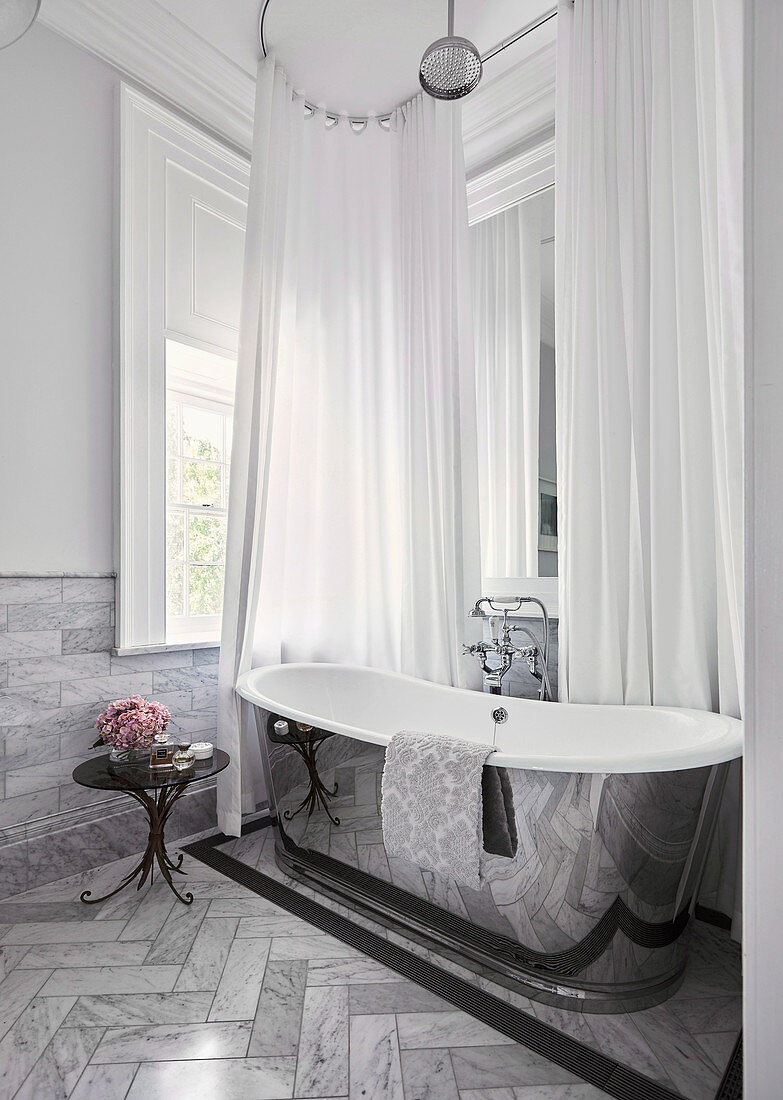 Silbern glänzende freistehende Badewanne im luxuriösen Bad