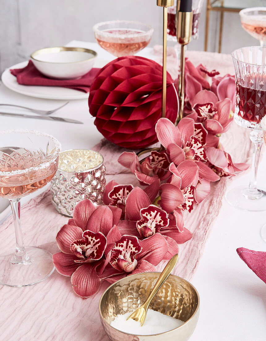 Centerpiece aus rosafarbenen Orchideen auf festlich gedecktem Tisch