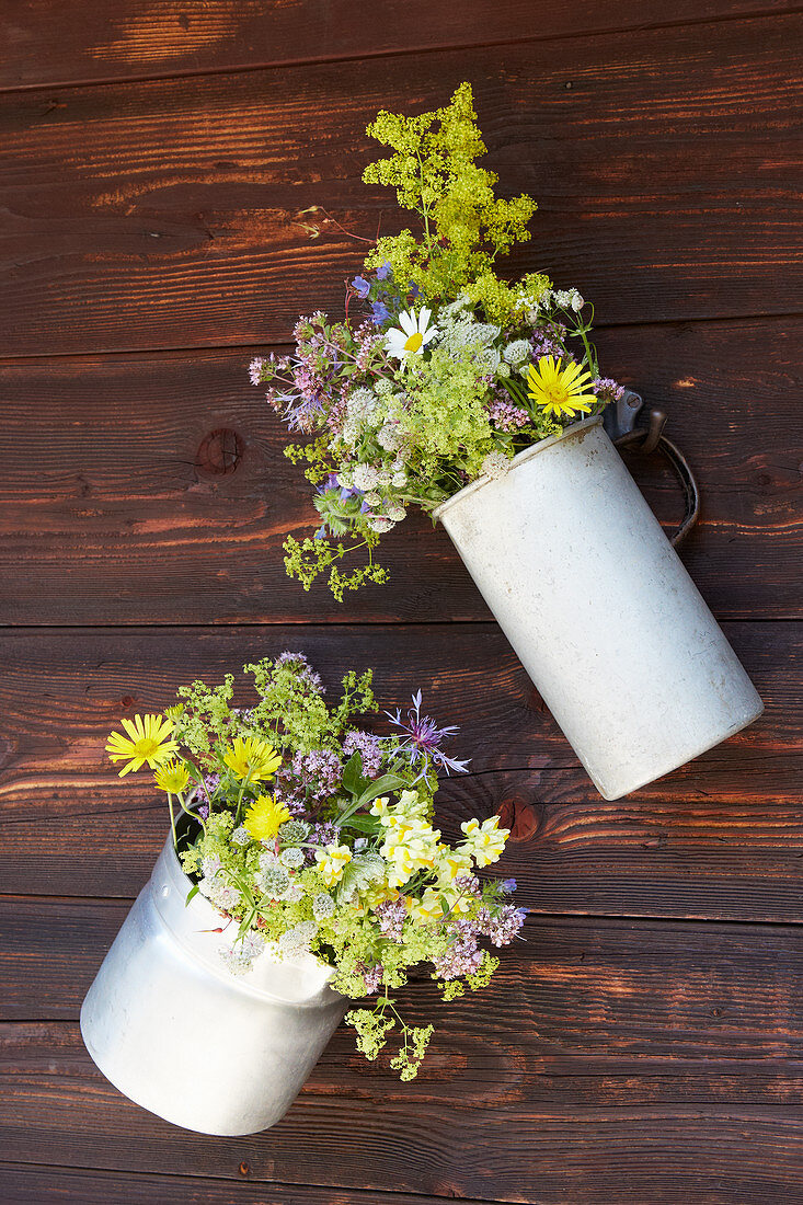Bunches of wildflowers in metal jugs