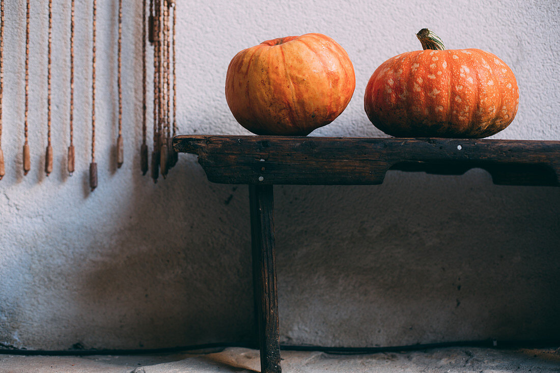 Two pumpkins on rustic wooden bench