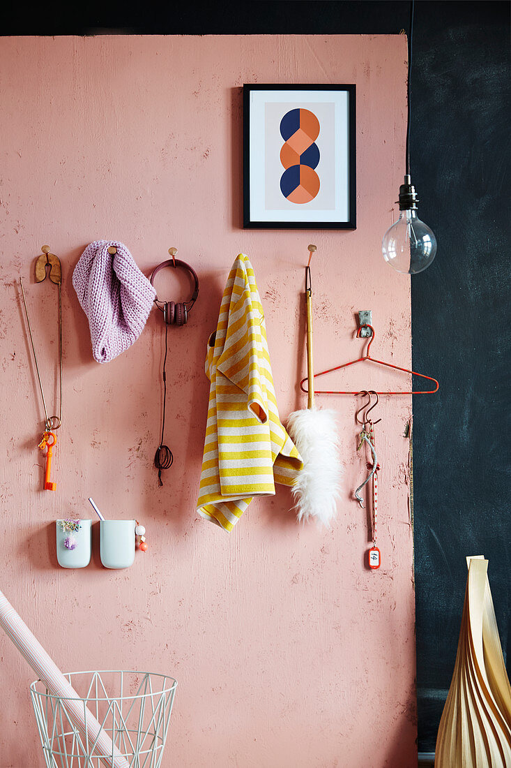 DIY-Garderobe aus übergroßen Nägeln an rosa Wand