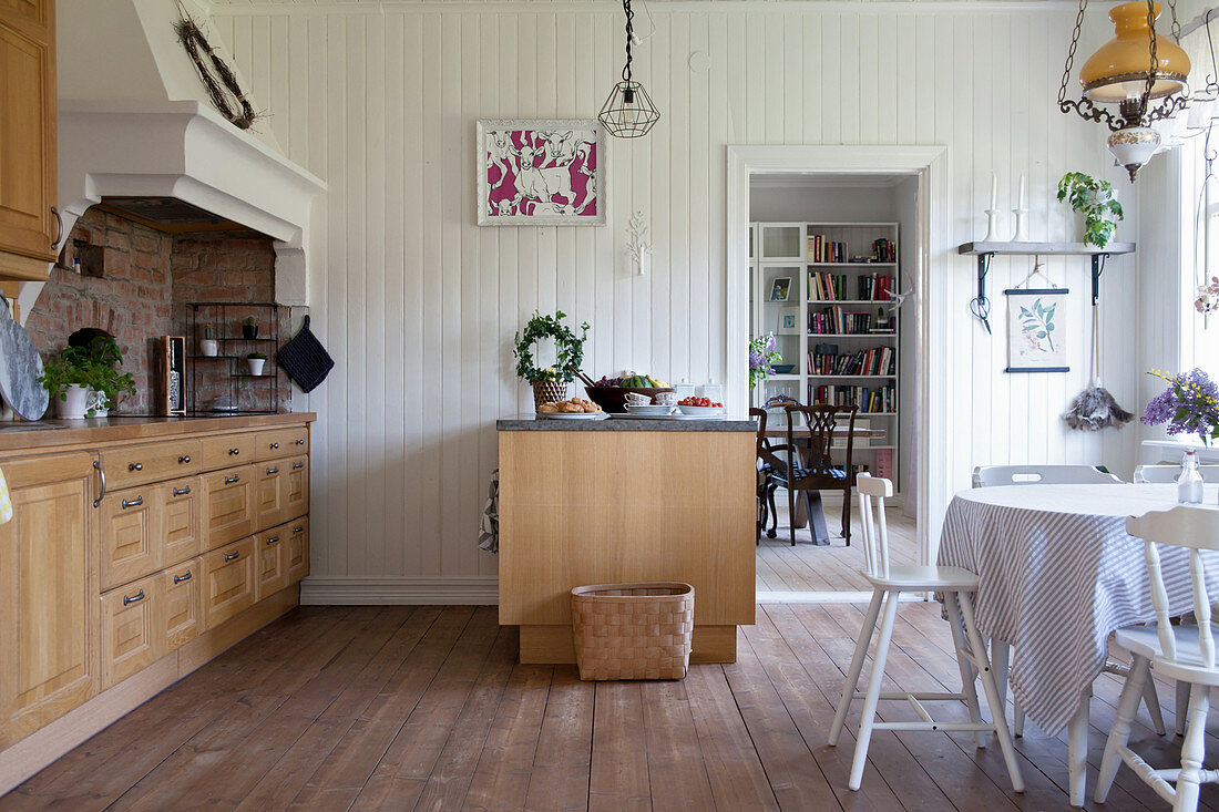 Küchenzeile mit Holzfront, Dunstabzugshaube, Theke und Essbereich in Wohnküche