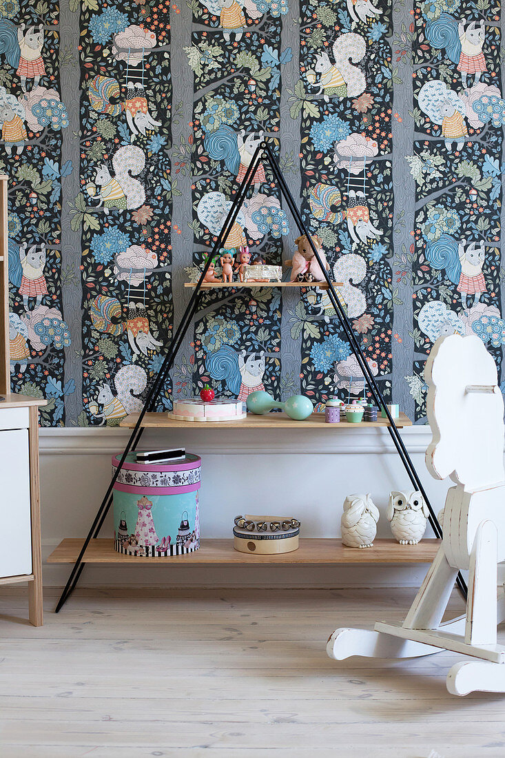 Pyramid shelves and rocking horse in child's bedroom with colourful wallpaper