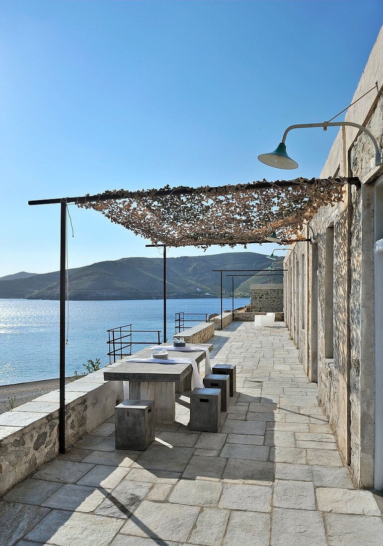Stone-flagged terrace with sea view under blue sky