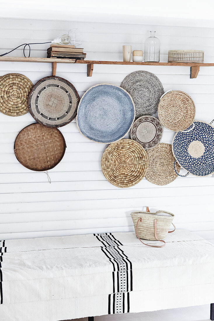 Arrangement of shallow baskets woven from natural materials decorating wall