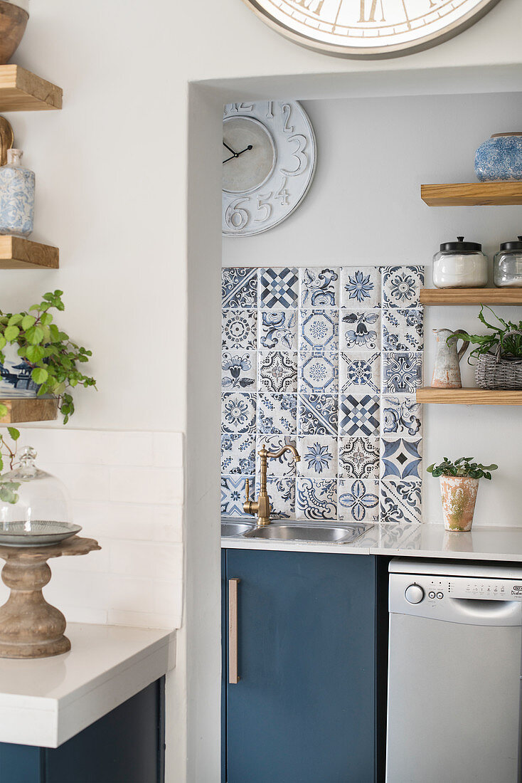 Blue-patterned tiles above sink in utility room