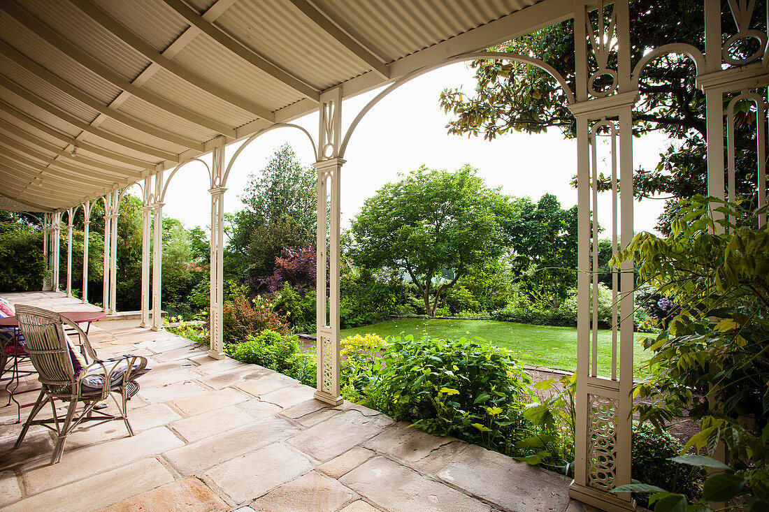 Blick von der Veranda mit Natursteinboden in den Garten