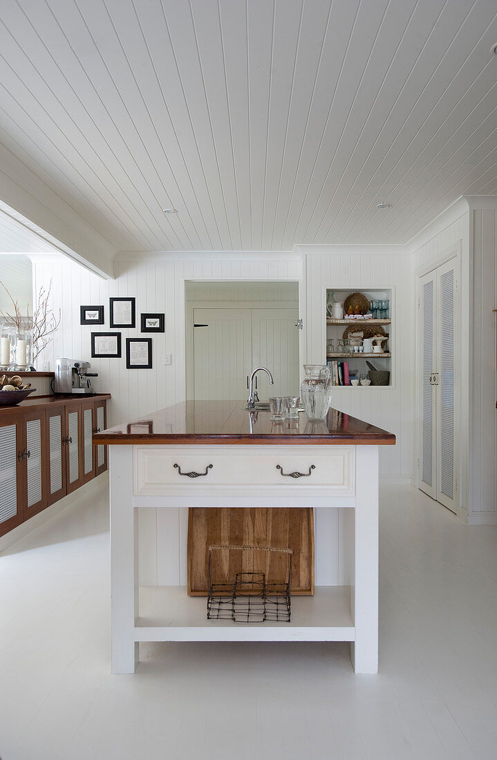 Island counter in large country-house kitchen with white floor