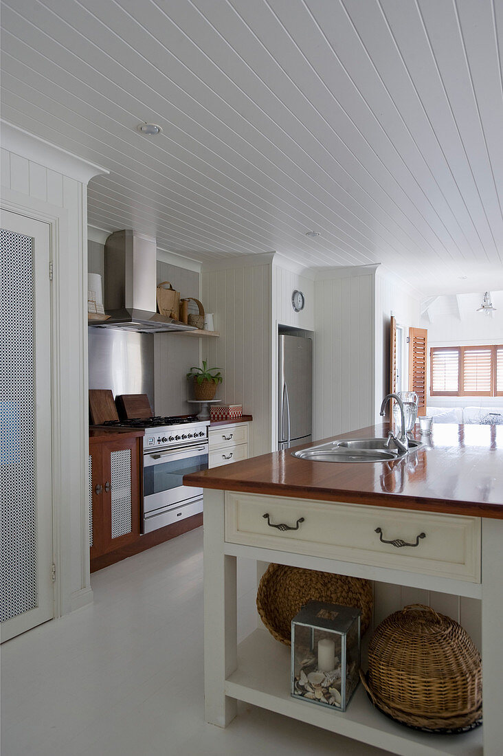 Island counter in large country-house kitchen with white floor
