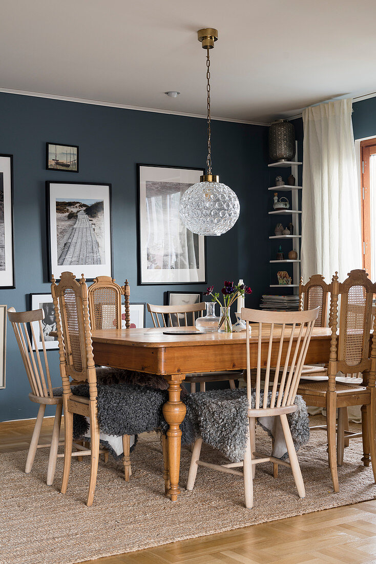 Holztisch und Stühle mit Tierfell im Esszimmer mit blauen Wänden