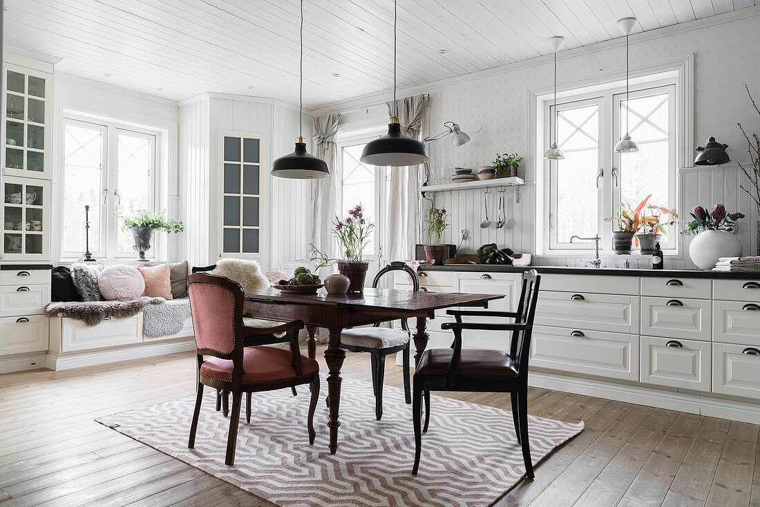 Antik Esstisch mit Stühlen, im Hintergrund Sitzbank in weißer Wohnküche