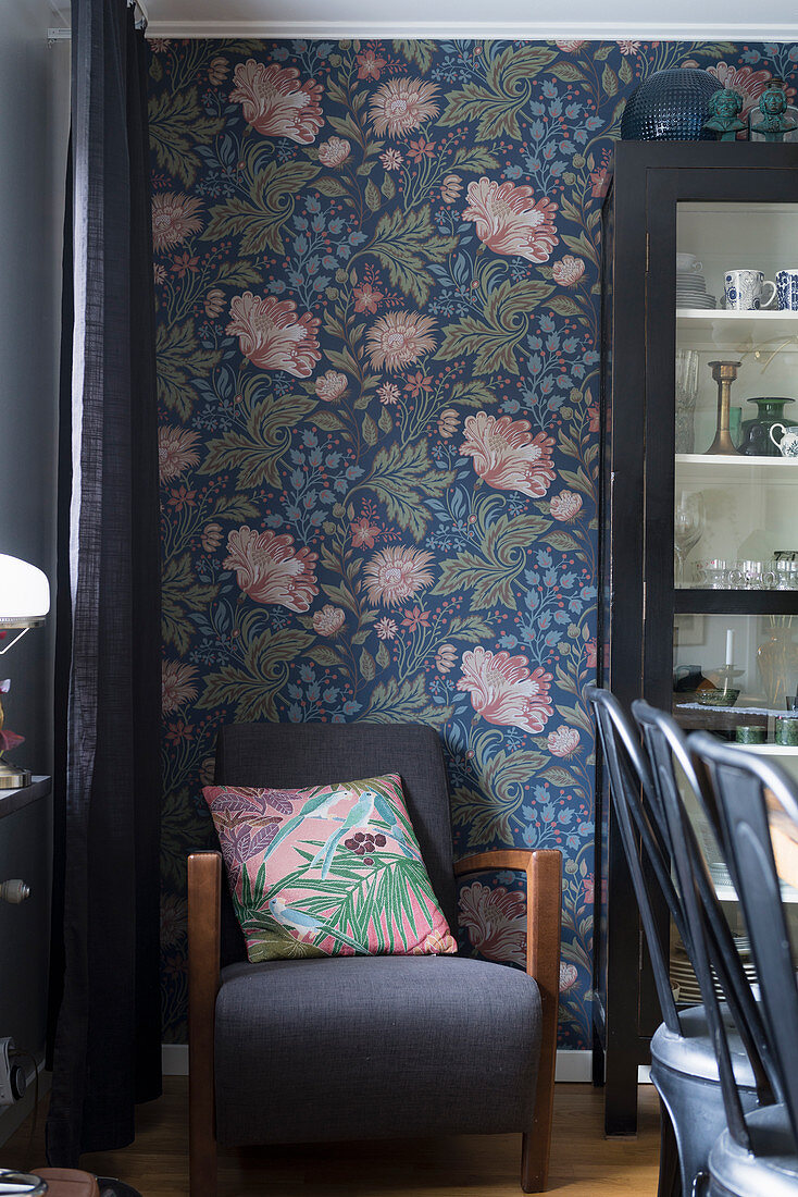 Cushion on armchair against floral wallpaper in dining area