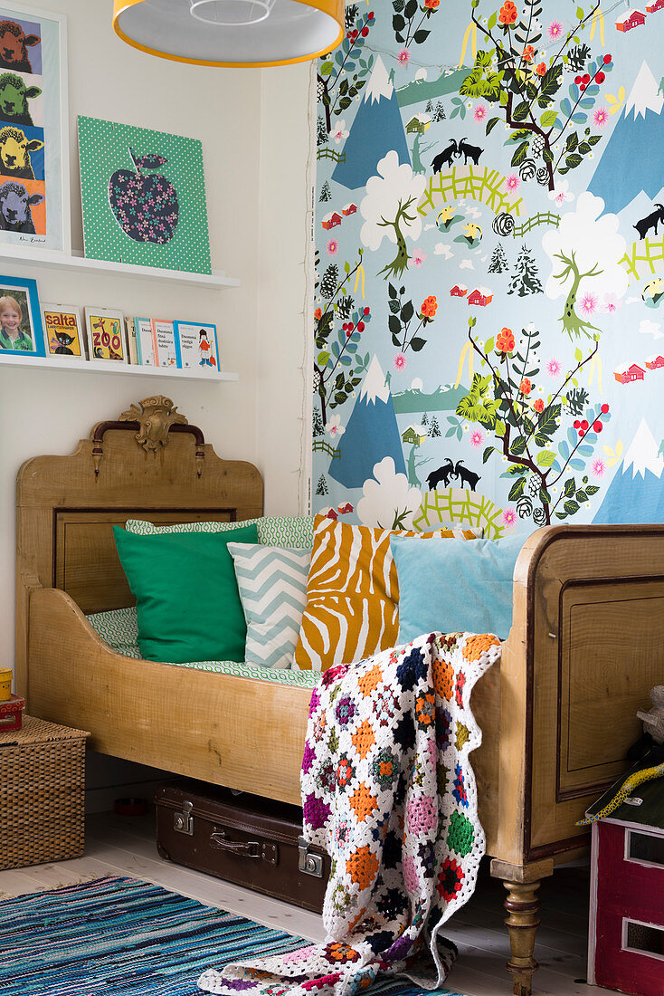 Wooden bed and colourful wallpaper in child's bedroom
