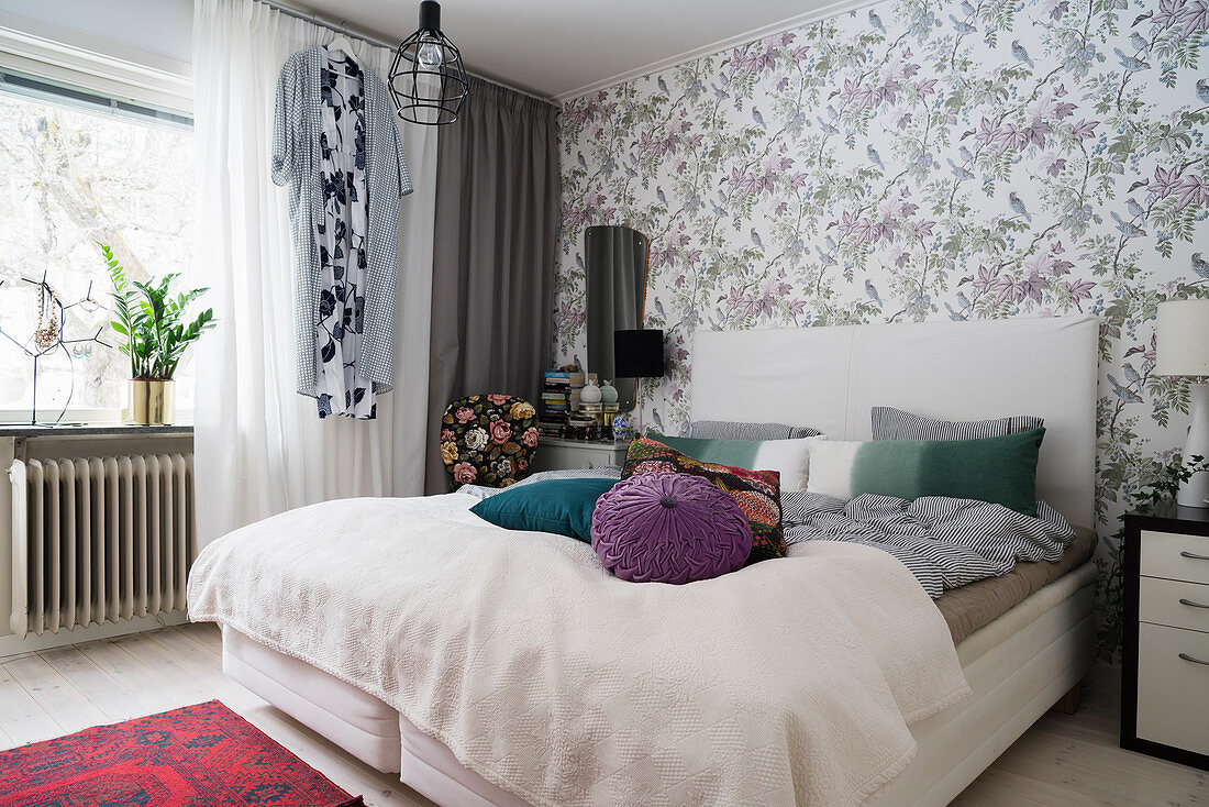 Doppelbett im Schlafzimmer mit Blumentapete