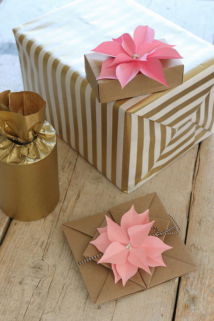 Pink paper flowers decorating wrapped gifts