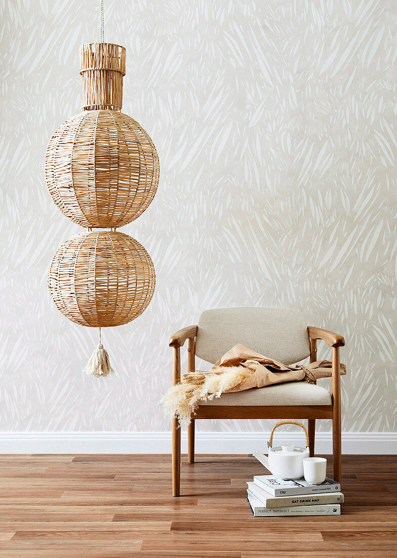 Ceiling lamp made of raffia balls next to an upholstered chair