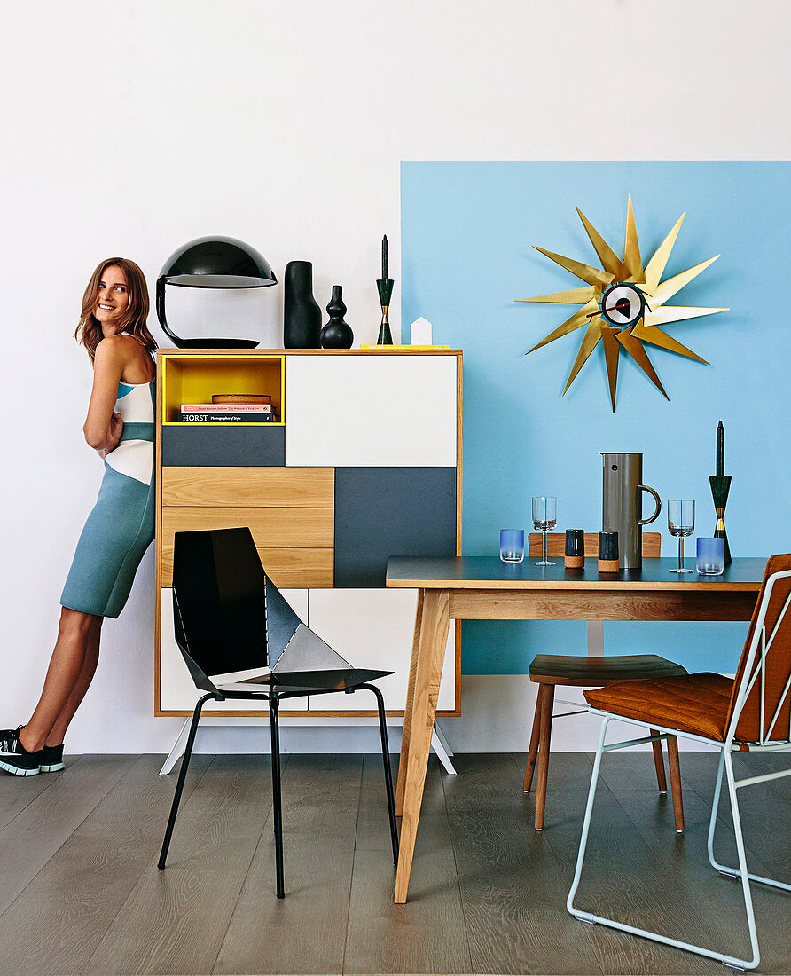 Woman leaning against a chest of drawers in the dining room with retro charm