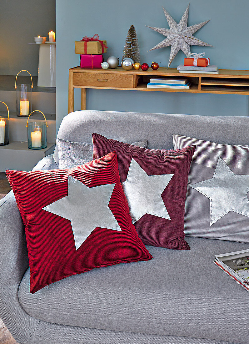 Homemade cushions with silver stars for Christmas on a sofa