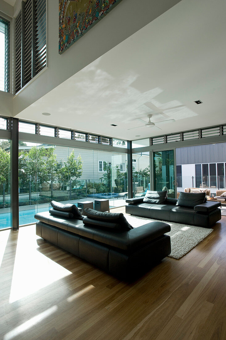 Two sofas facing one another in modern house with glass walls