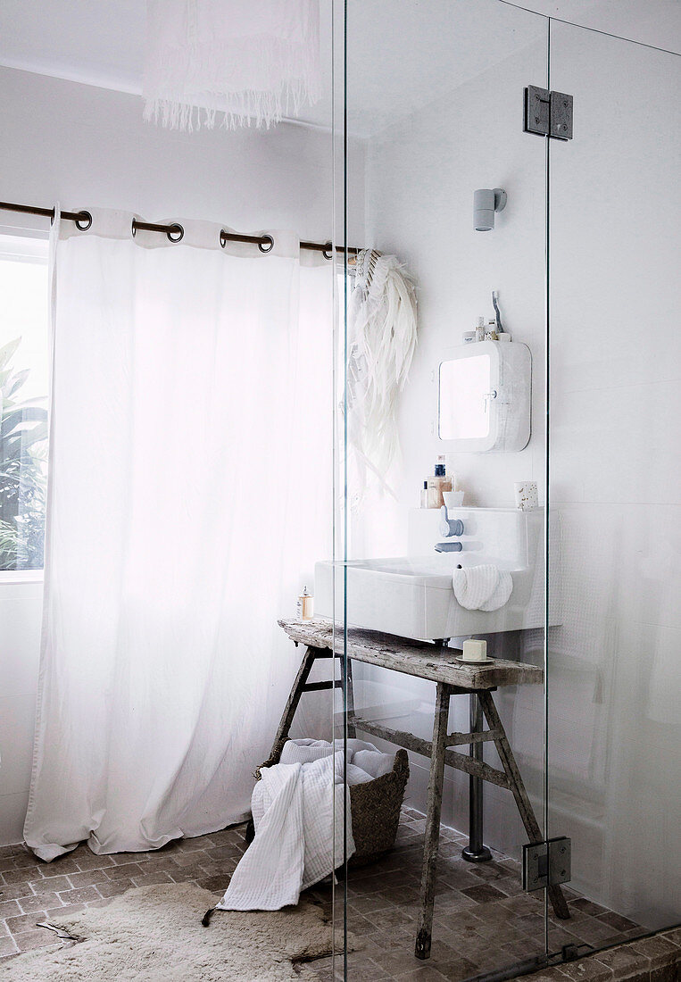 Vintage-Badezimmer in Weiß mit Waschbecken auf altem Holzbock