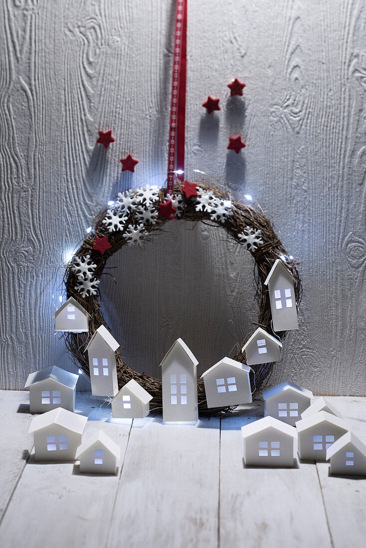 Weihnachtskranz mit Lichterkette und beleuchtete Häuschen aus Papier