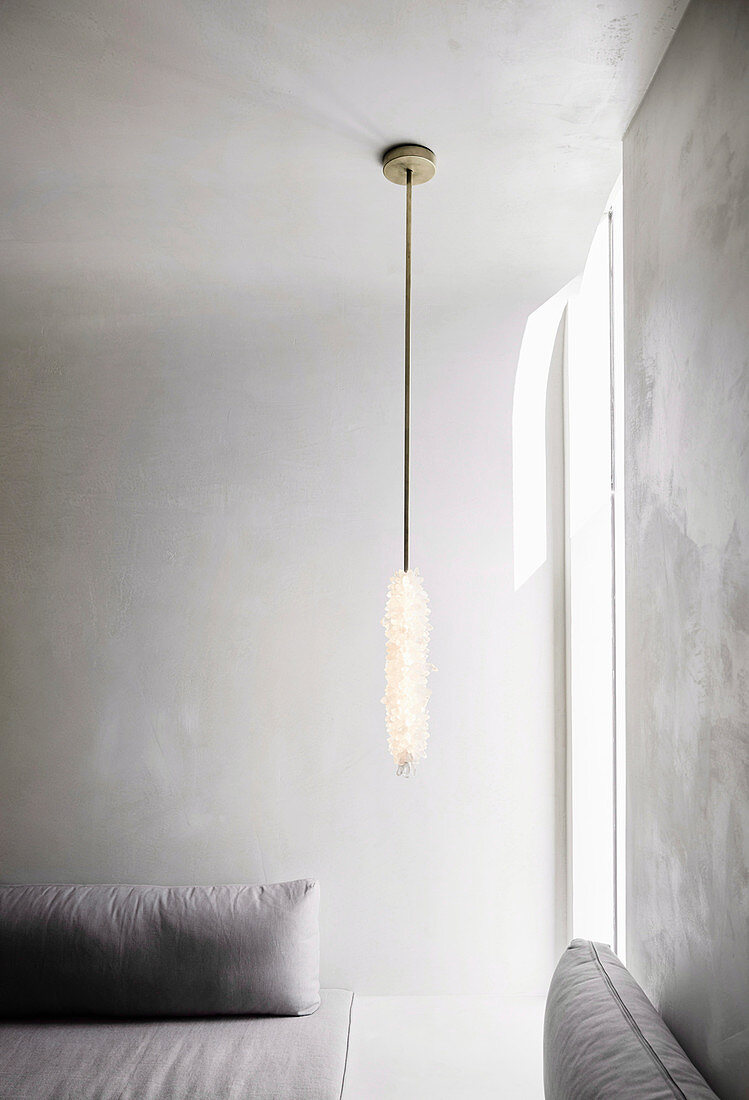 Tief hängende Deckenleuchte im minimalistischen Wohnzimmer