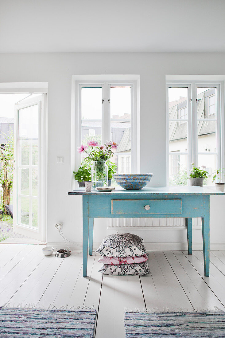 Alter blauer Tisch Sprossenfenstern und der Tür zum Garten