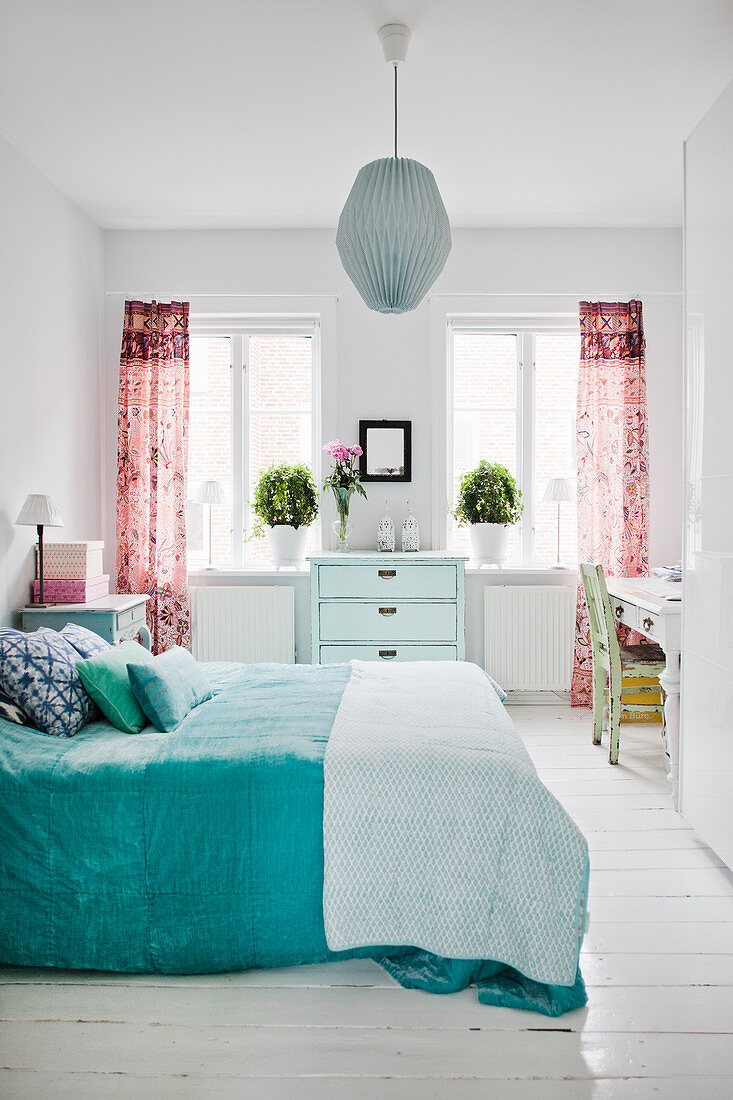 Freundliches Schlafzimmer in Weiß mit farbigen Akzenten