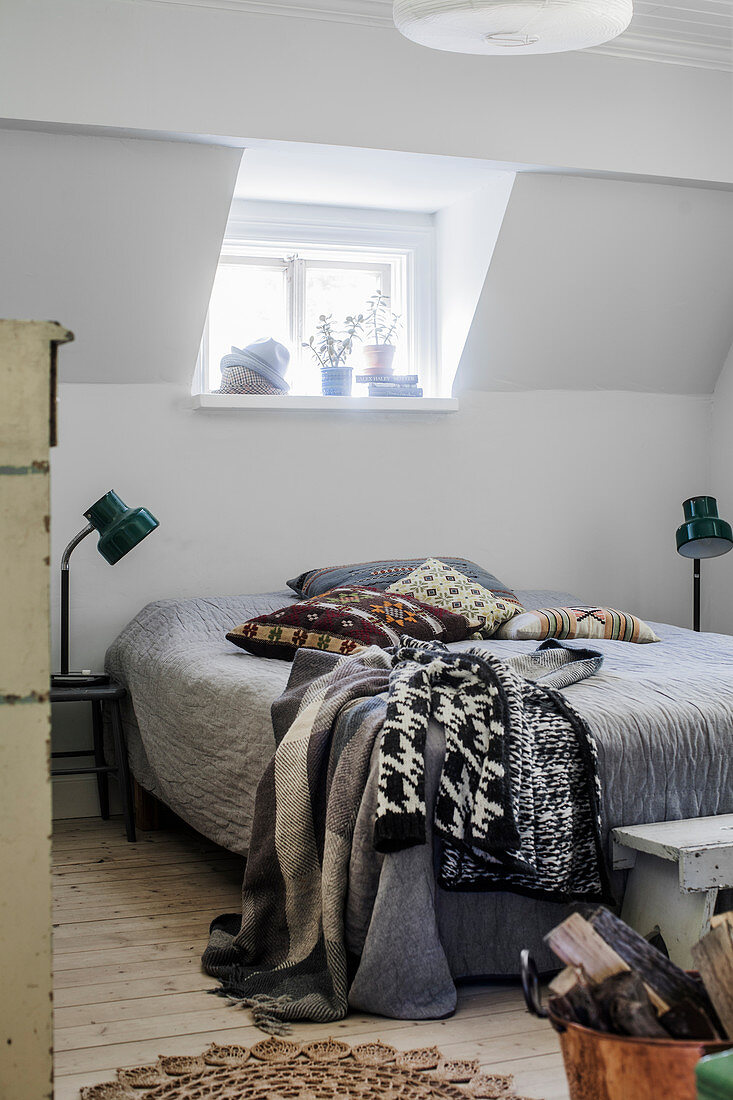 Bedspread and woollen blankets on double bed in attic bedroom