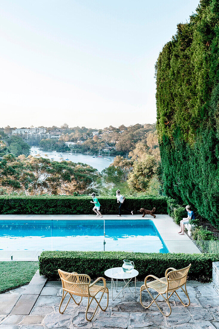 Poolside terrace with panoramic water views, children playing