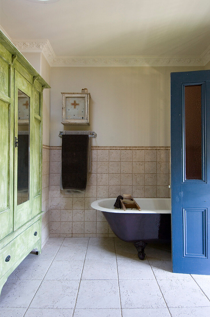 Offene blaue Tür zum Bad mit grünem Kleiderschrank