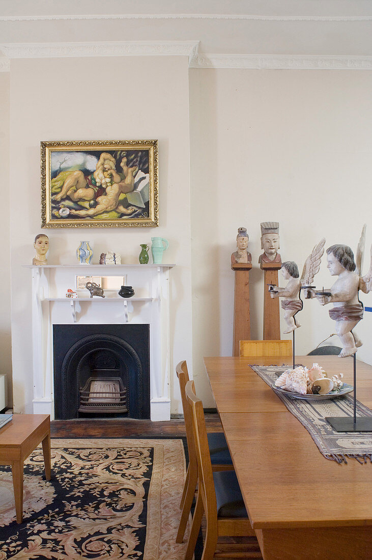 Esstisch mit Putten, Kunstwerke und Kamin in offenem Wohnraum