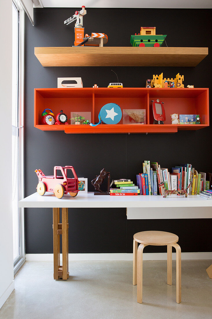 Regale und Schreibtisch an schwarzer Wand im Kinderzimmer