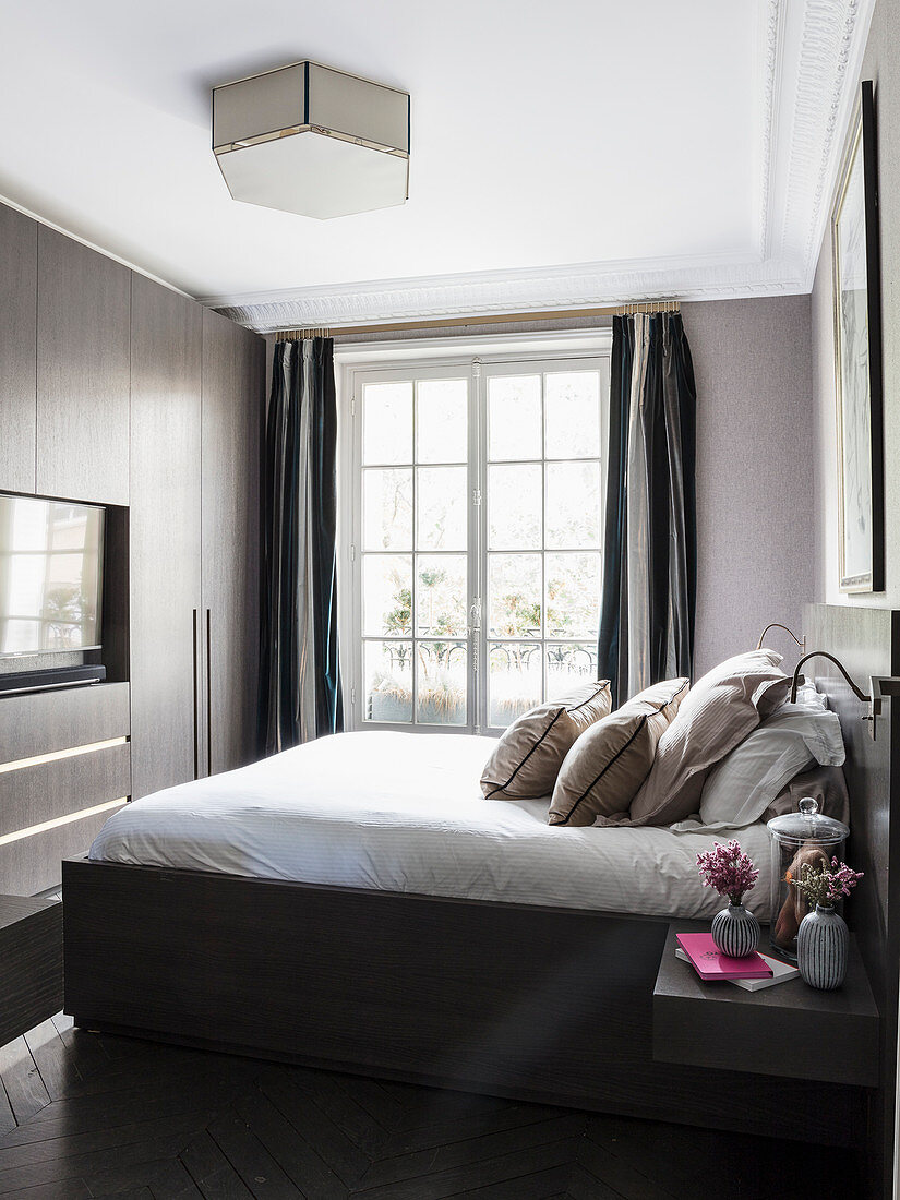 Classic bedroom in dark shades with fitted cupboards