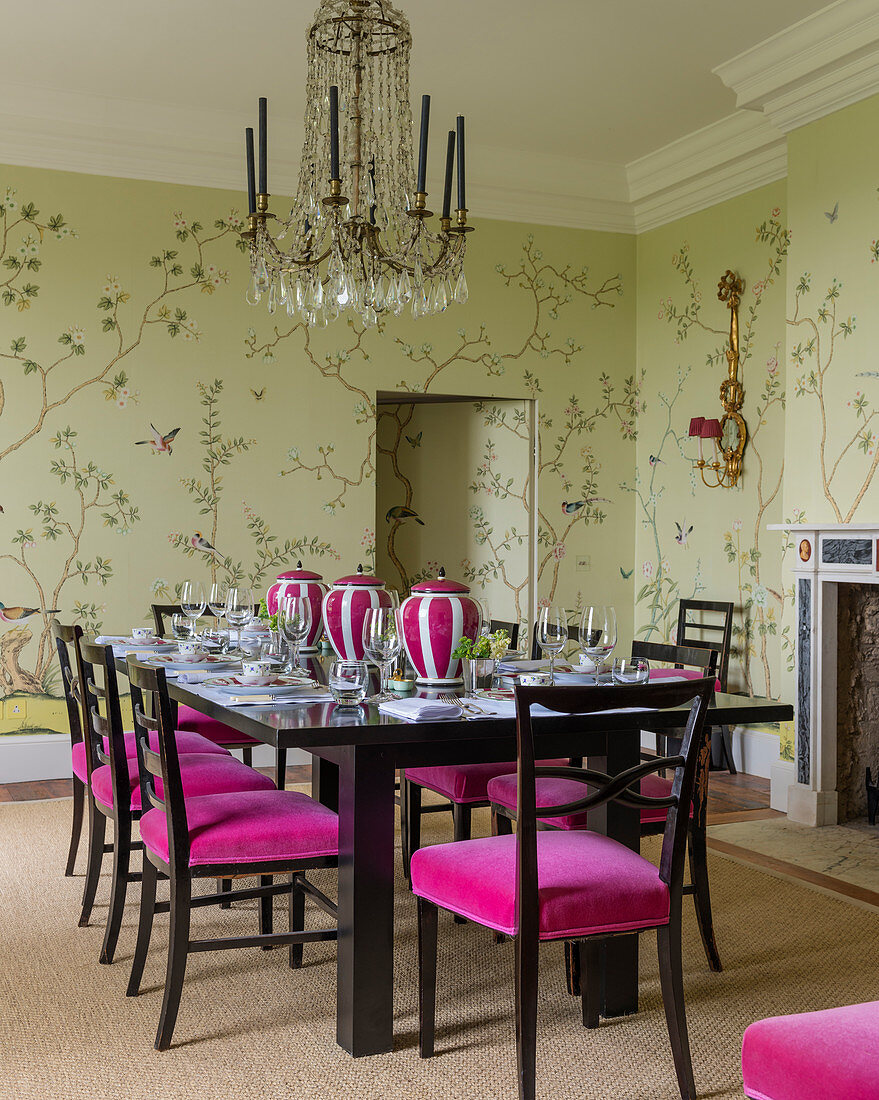 Wallpaper in dining room with French crystal chandelier and dining chairs upholstered in velvet