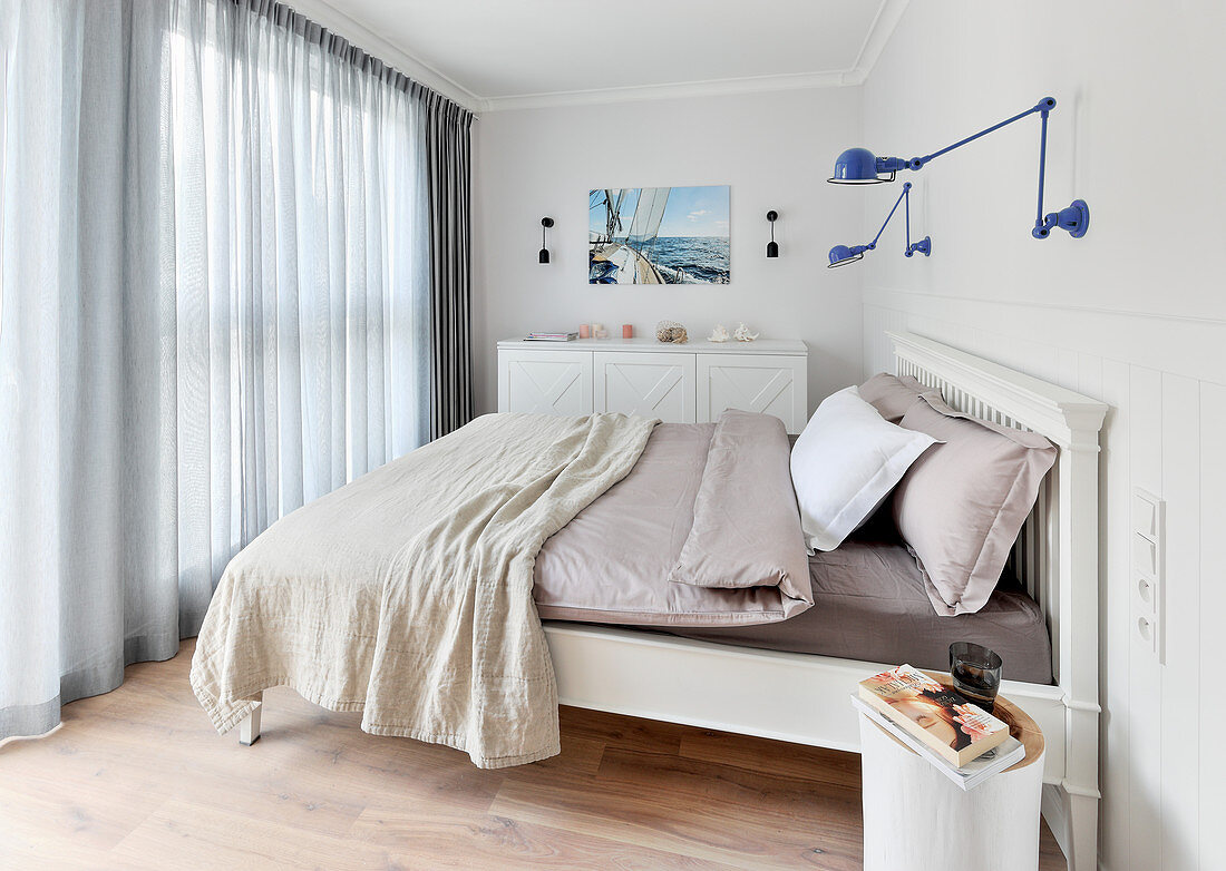 Blue wall-mounted lamps above bed in bedroom