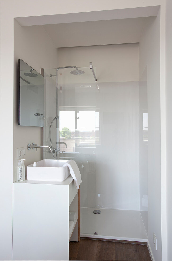 Weißer Waschtisch mit Aufsatzbecken und Duschbereich in kleinem Badezimmer