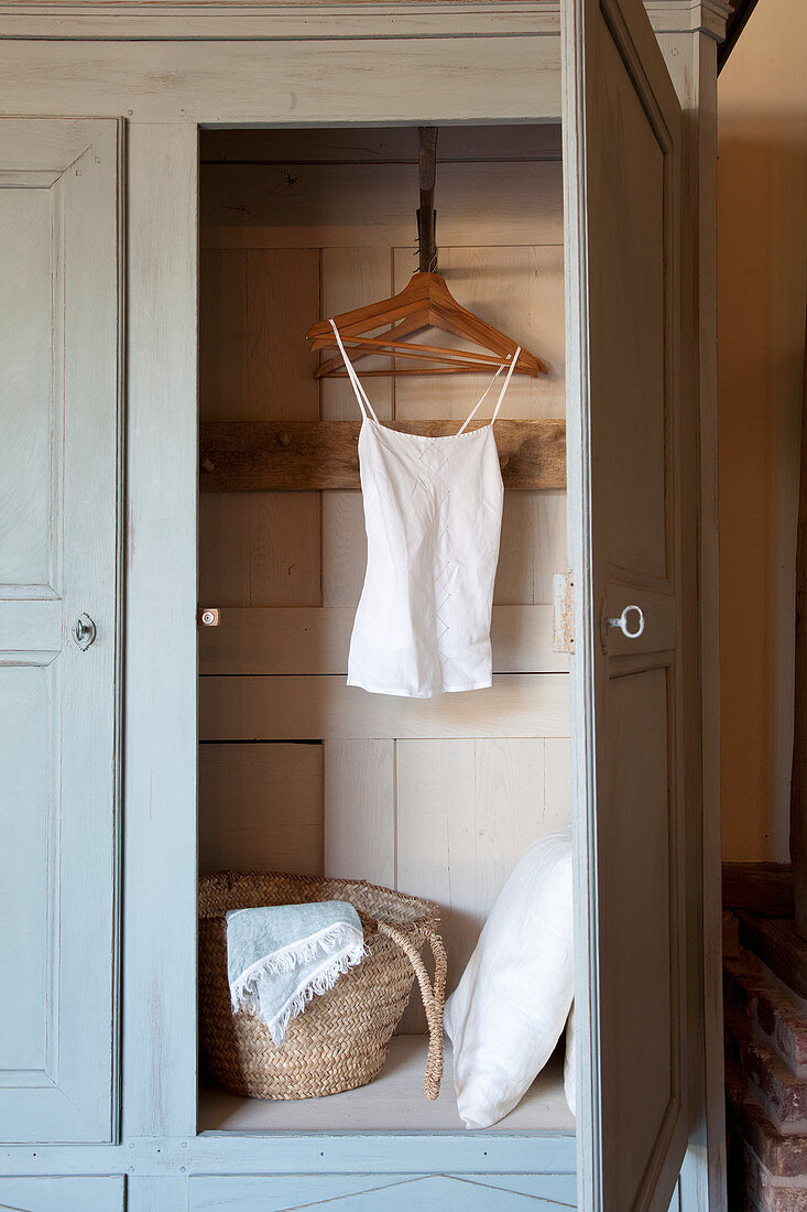 Top on coat hanger and cushions in old wooden wardrobe