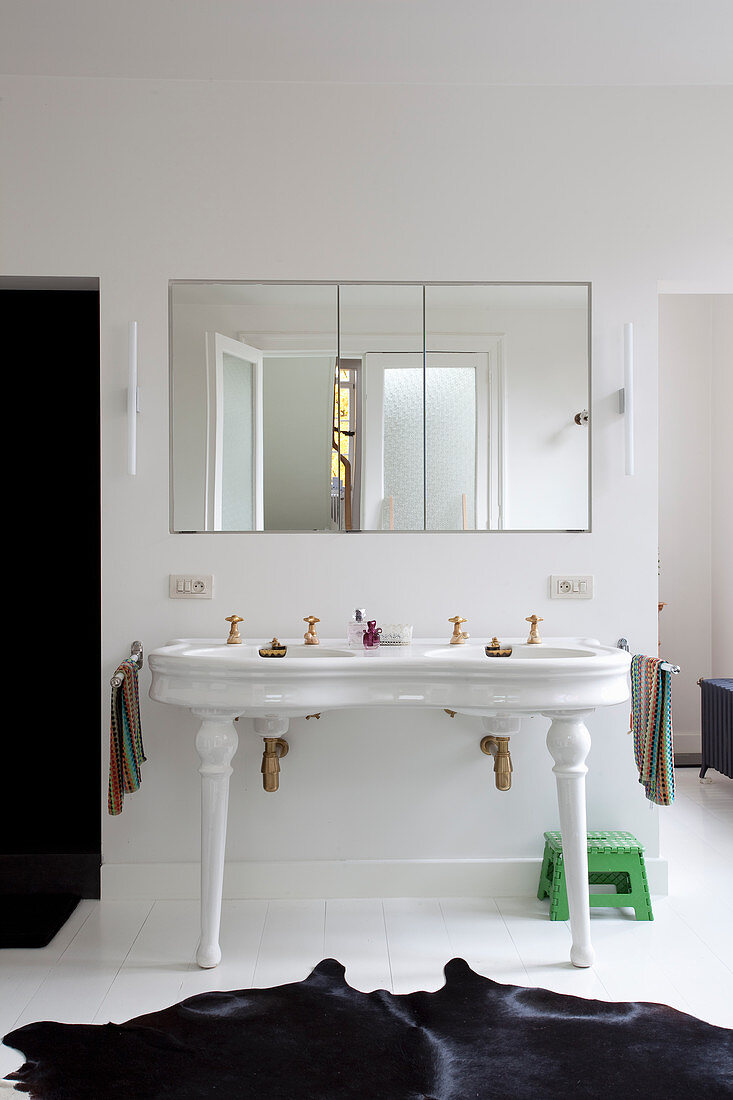 Vintage double sink and black cowhide rug in bathroom