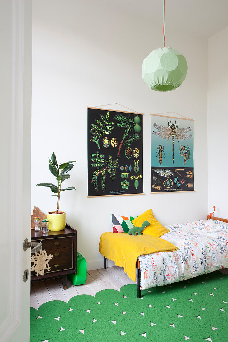 Green rug and vintage-style posters in child's bedroom