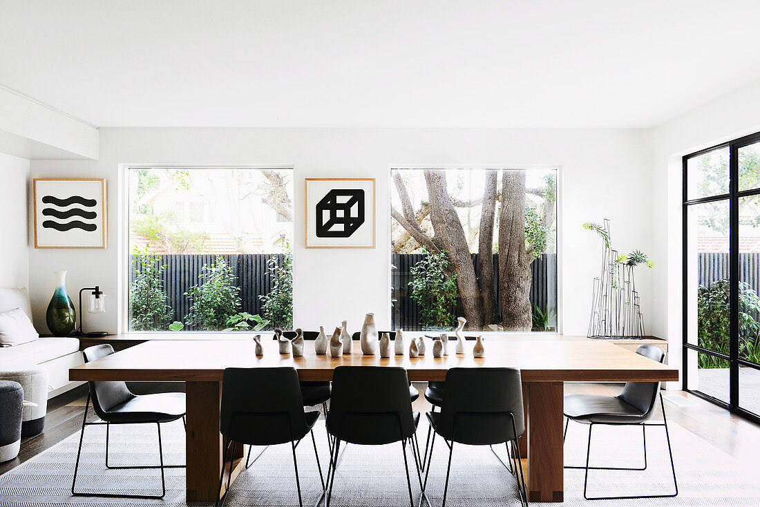 Wooden dining table with black chairs in a bright living room