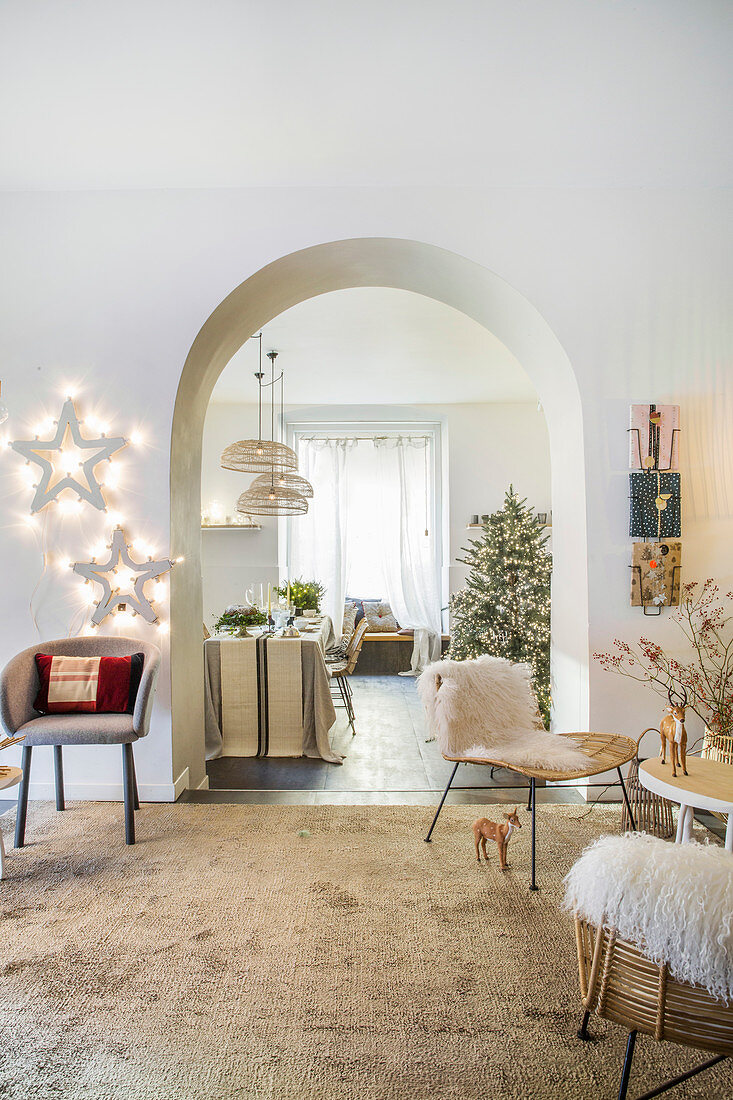 Festively decorated living room with open archway leading into dining room