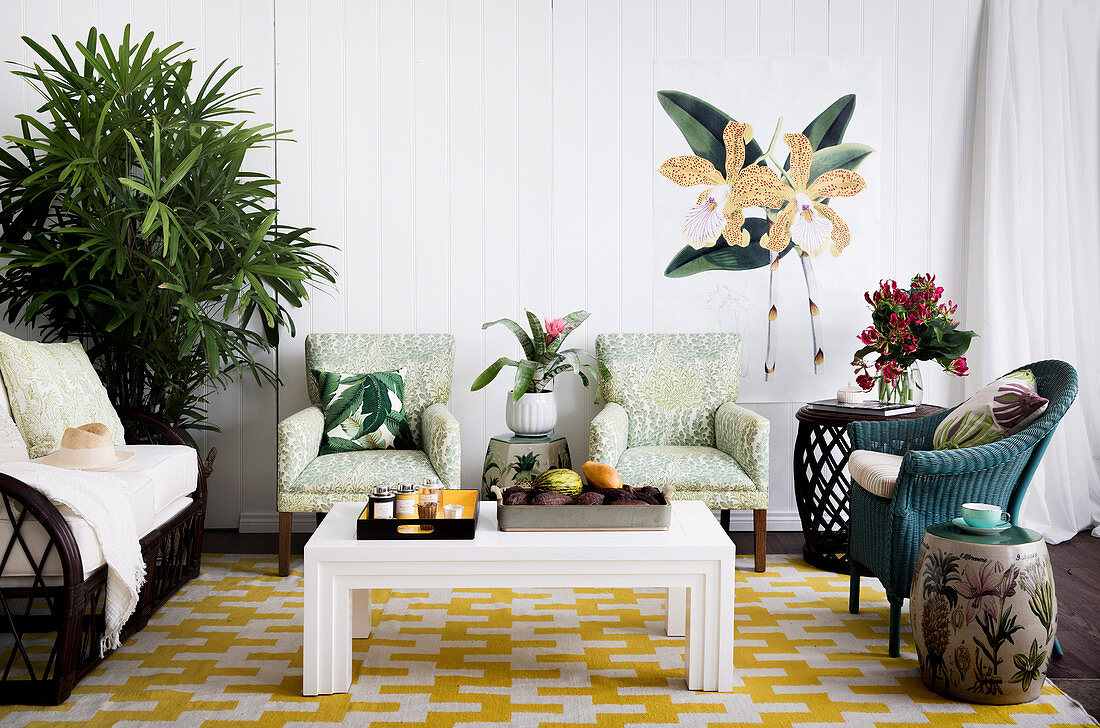 Verschiedene Sitzmöbel, Beistelltische, Couchtisch-Set und Grünpflanze im Wohnzimmer