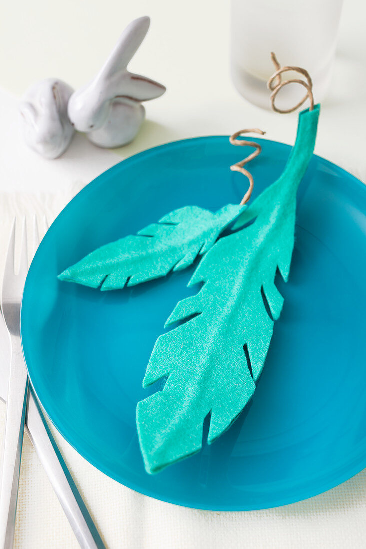 Turquoise felt feathers on blue plate