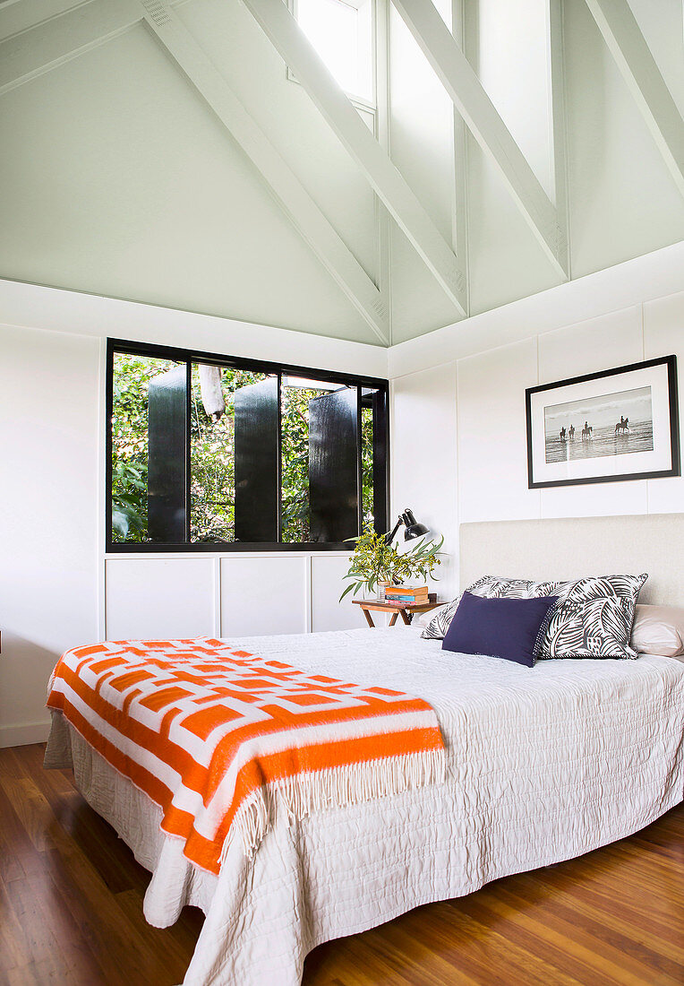 Doppelbett in hellem Schlafzimmer mit Giebeldach