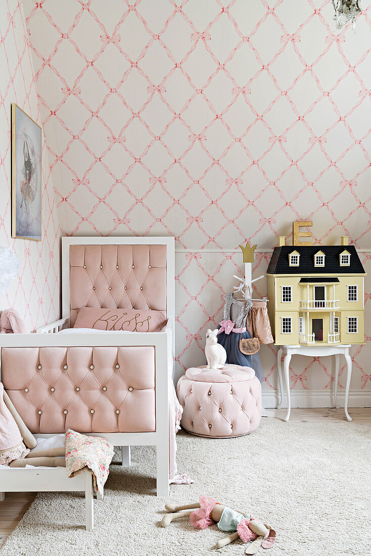 Bett, Pouf und Puppenhaus im Mädchenzimmer in hellen Pastelltönen