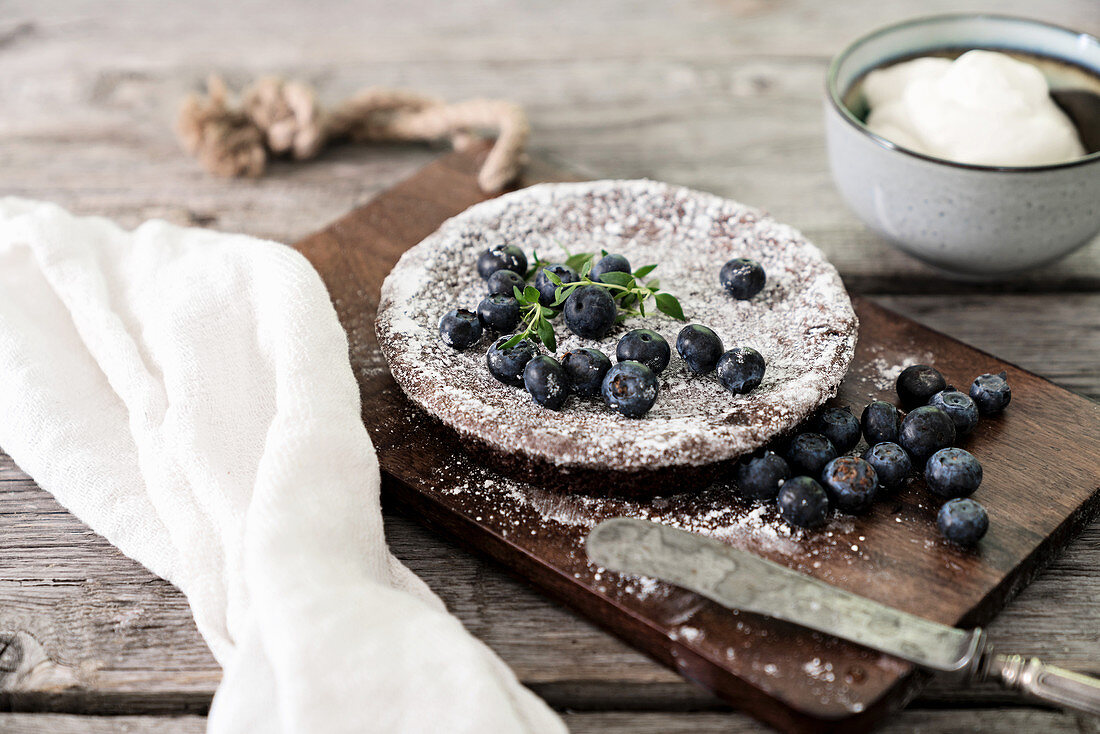 Chocolate torte with blueberries on wooden board