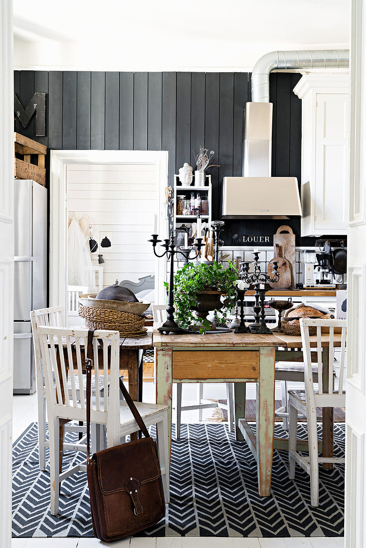 Three wooden tables in dining area of vintage-style country-house kitchen